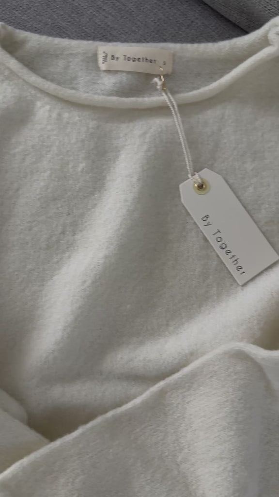 Close-up video of Piper soft knit crew sweater in off white highlighting fabric texture