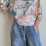 Model wearing the Livia Made in Italy batwing printed sweater with playful cats print, showing real fit and movement.