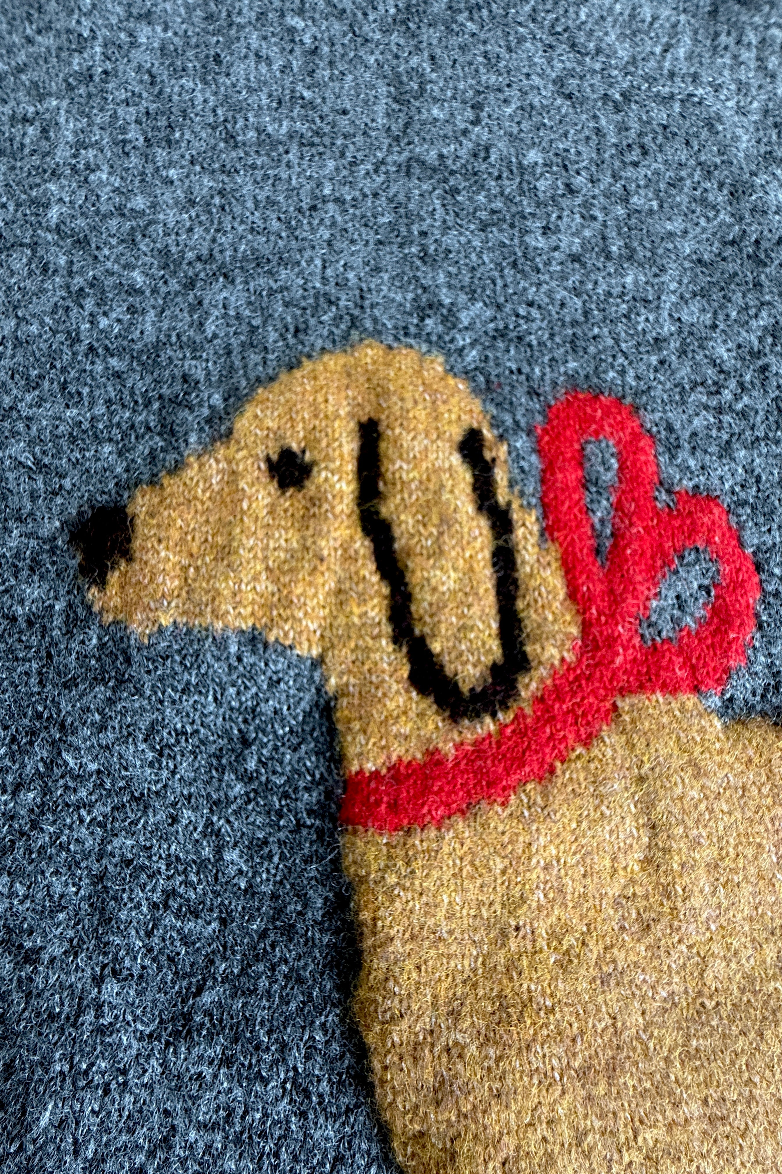 Close-up of dog print with red bow on Puppy Love sweater