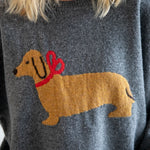 Close-up of dog illustration with red bow on Puppy Love sweater