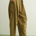 Side view of Quinn green and stone pinstripe cotton pants with billowy harem silhouette