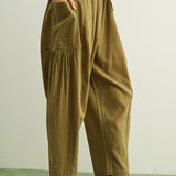 Side view of Quinn green and stone pinstripe cotton pants with billowy harem silhouette