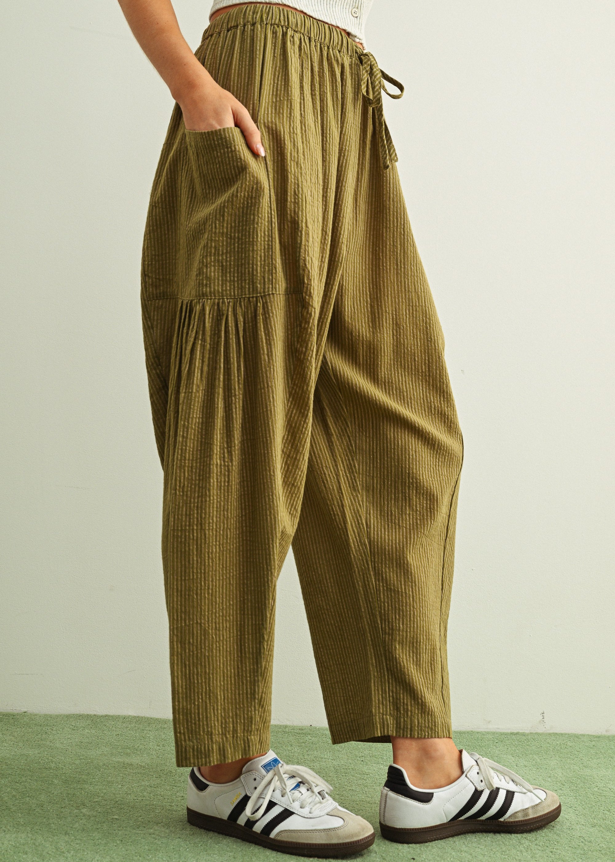 Side view of Quinn green and stone pinstripe cotton pants with billowy harem silhouette