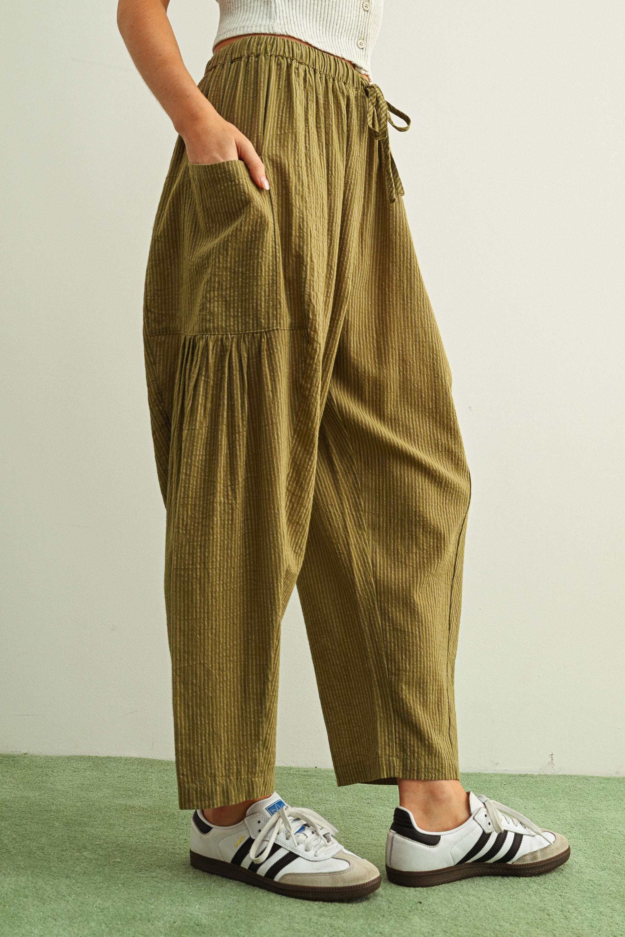 Side view of Quinn green and stone pinstripe cotton pants with billowy harem silhouette