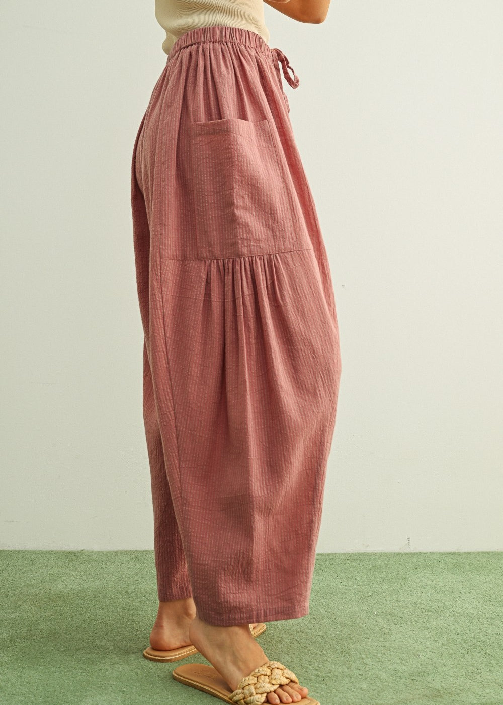 Side view of Quinn pink and stone pinstripe cotton harem pants with dropped pockets