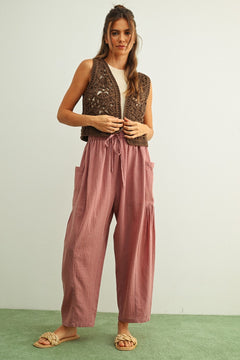 Woman wearing a brown patterned vest and  Quinn pink and stone pinstripe cotton harem pants with dropped pockets