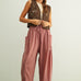 Woman wearing a brown patterned vest and  Quinn pink and stone pinstripe cotton harem pants with dropped pockets