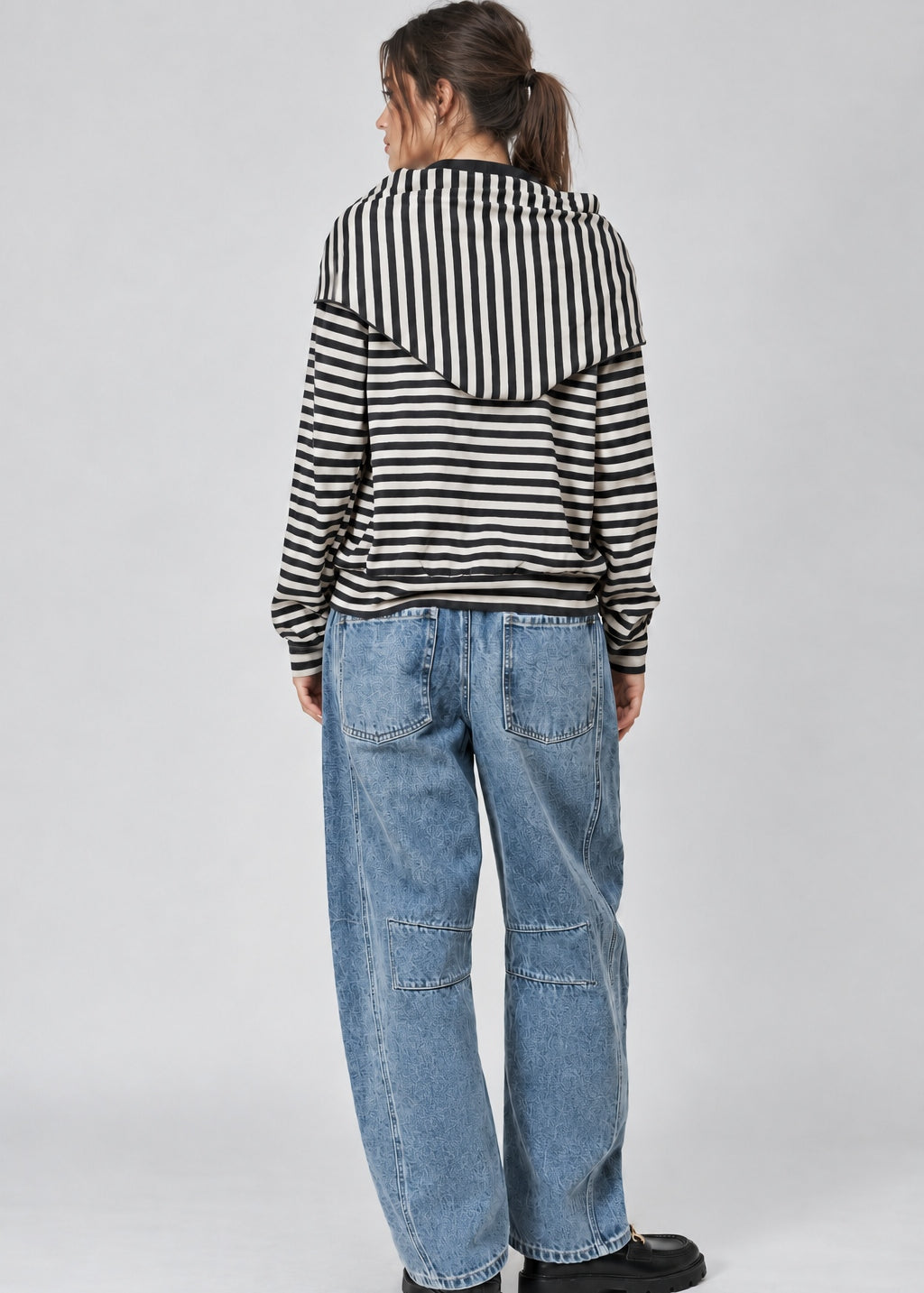 Back studio view of the Remi striped sweatshirt showing its relaxed fit and matching black and cream hip scarf