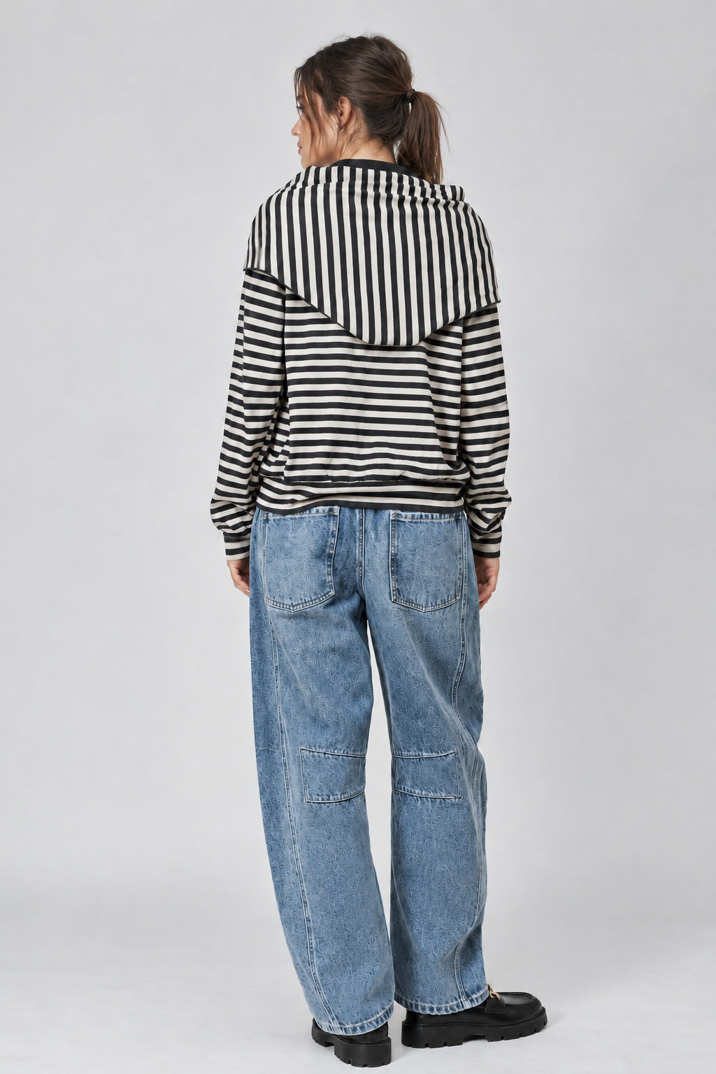 Back studio view of the Remi striped sweatshirt showing its relaxed fit and matching black and cream hip scarf