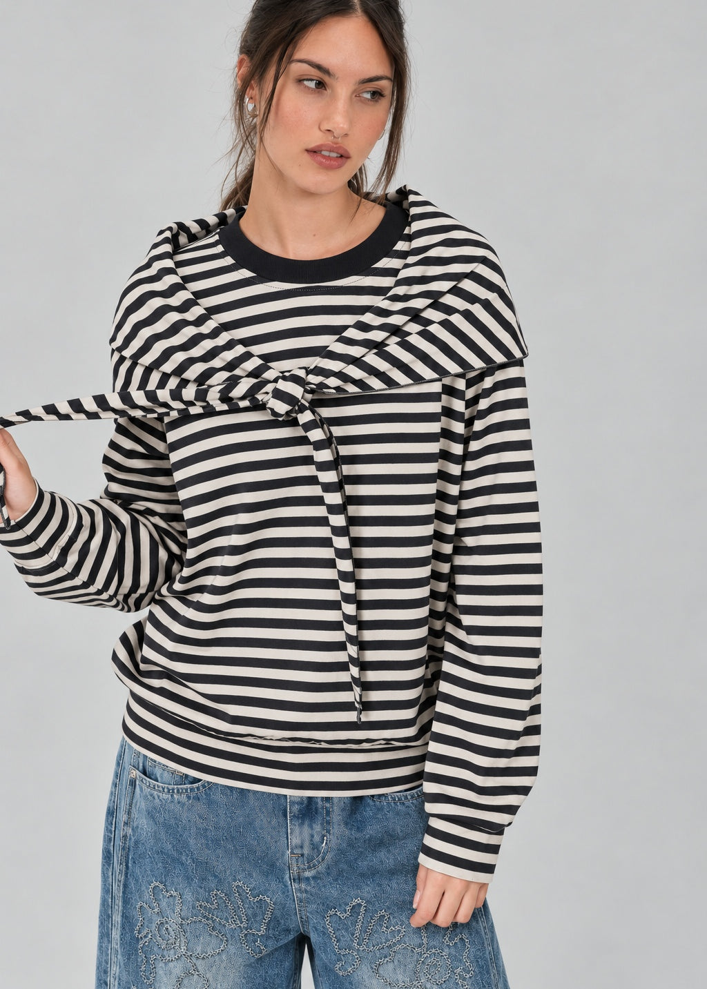 Front studio view of the Remi black and cream striped cotton sweatshirt with matching triangle scarf tied around the hips