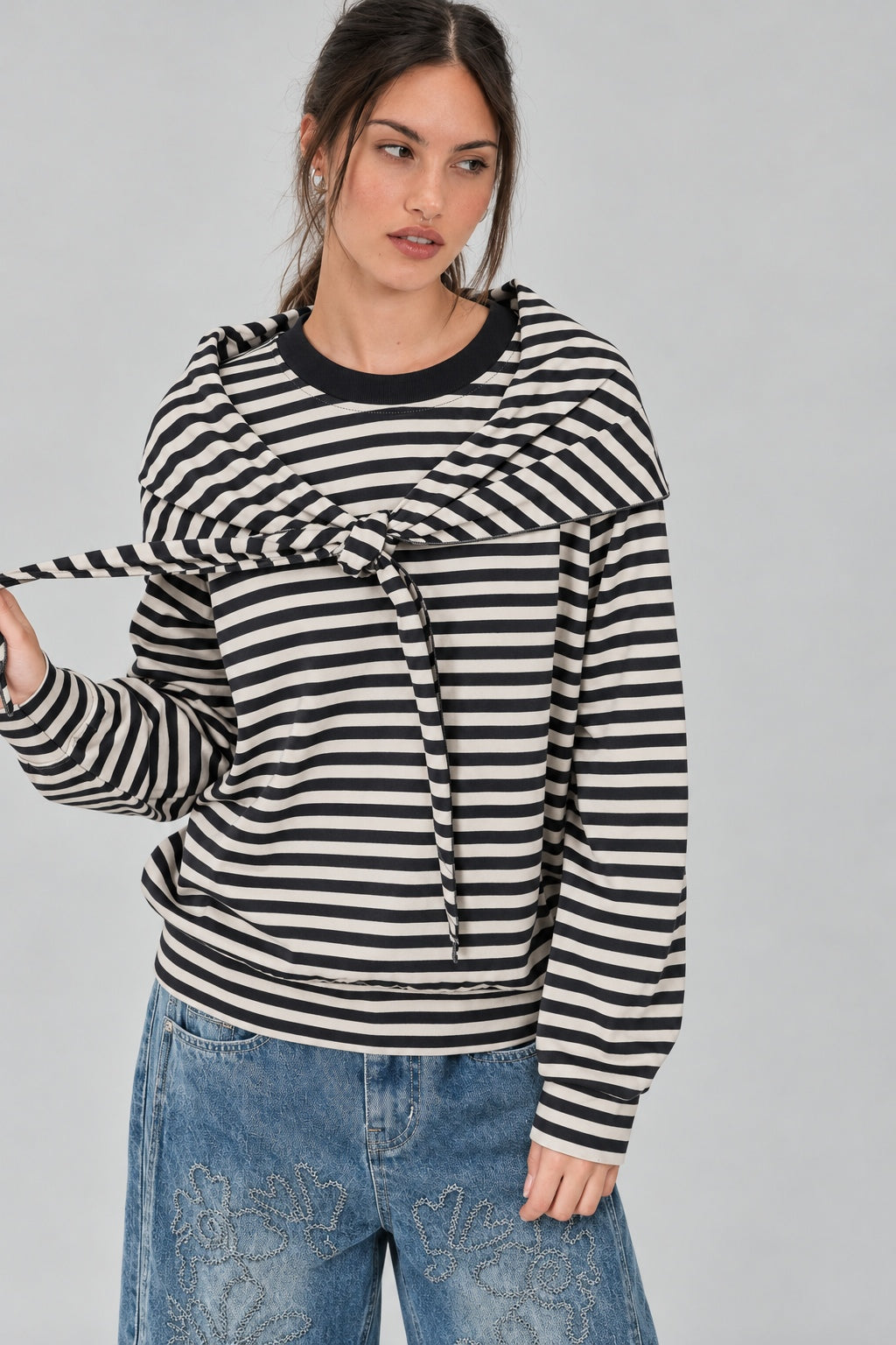 Front studio view of the Remi black and cream striped cotton sweatshirt with matching triangle scarf tied around the hips