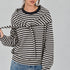 Front studio view of the Remi black and cream striped cotton sweatshirt with matching triangle scarf tied around the hips
