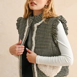 Close-up front view of the black gingham vest showing button-down front, stand collar, and ruffled shoulders