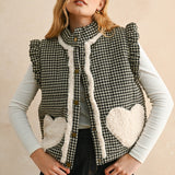 Model wearing the Rosie Gingham Sherpa Puffer Vest in black, front portrait view with sherpa heart pockets