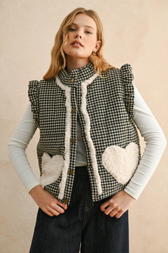 Model wearing the Rosie Gingham Sherpa Puffer Vest in black, front portrait view with sherpa heart pockets