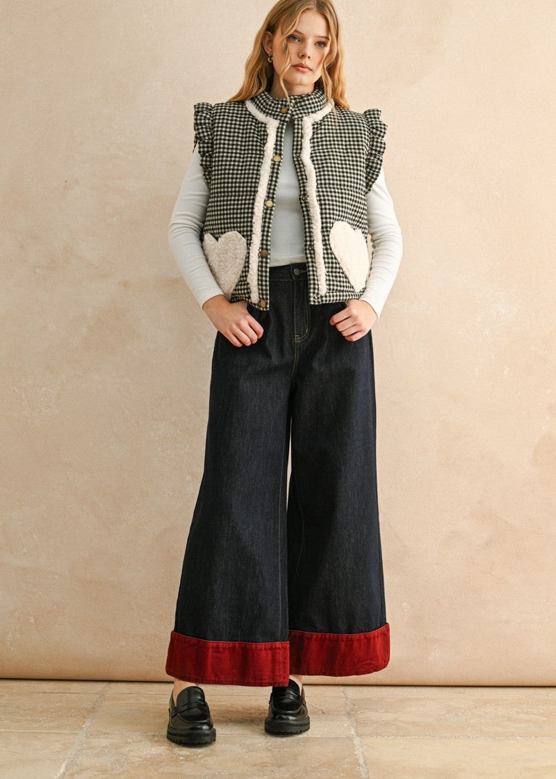 Full-body view of the black gingham sherpa puffer vest styled with dark pants and layered top