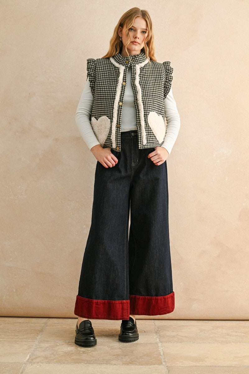 Full-body view of the black gingham sherpa puffer vest styled with dark pants and layered top