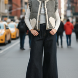 Outdoor street-style photo of the Rosie gingham sherpa puffer vest in black, front view while walking