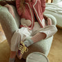 Cozy indoor portrait of model wearing the Rosie Gingham Sherpa Puffer Vest in red with sherpa heart pockets