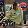 Lifestyle image of model wearing the Sardine Balloon Sleeve Sweater in olive inside a record store