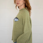 Side view of the Sardine Balloon Sleeve Sweater in olive showing sleeve volume and drape
