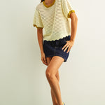 Woman wearing cream scalloped mesh knit short sleeve cotton top with lemongrass trim