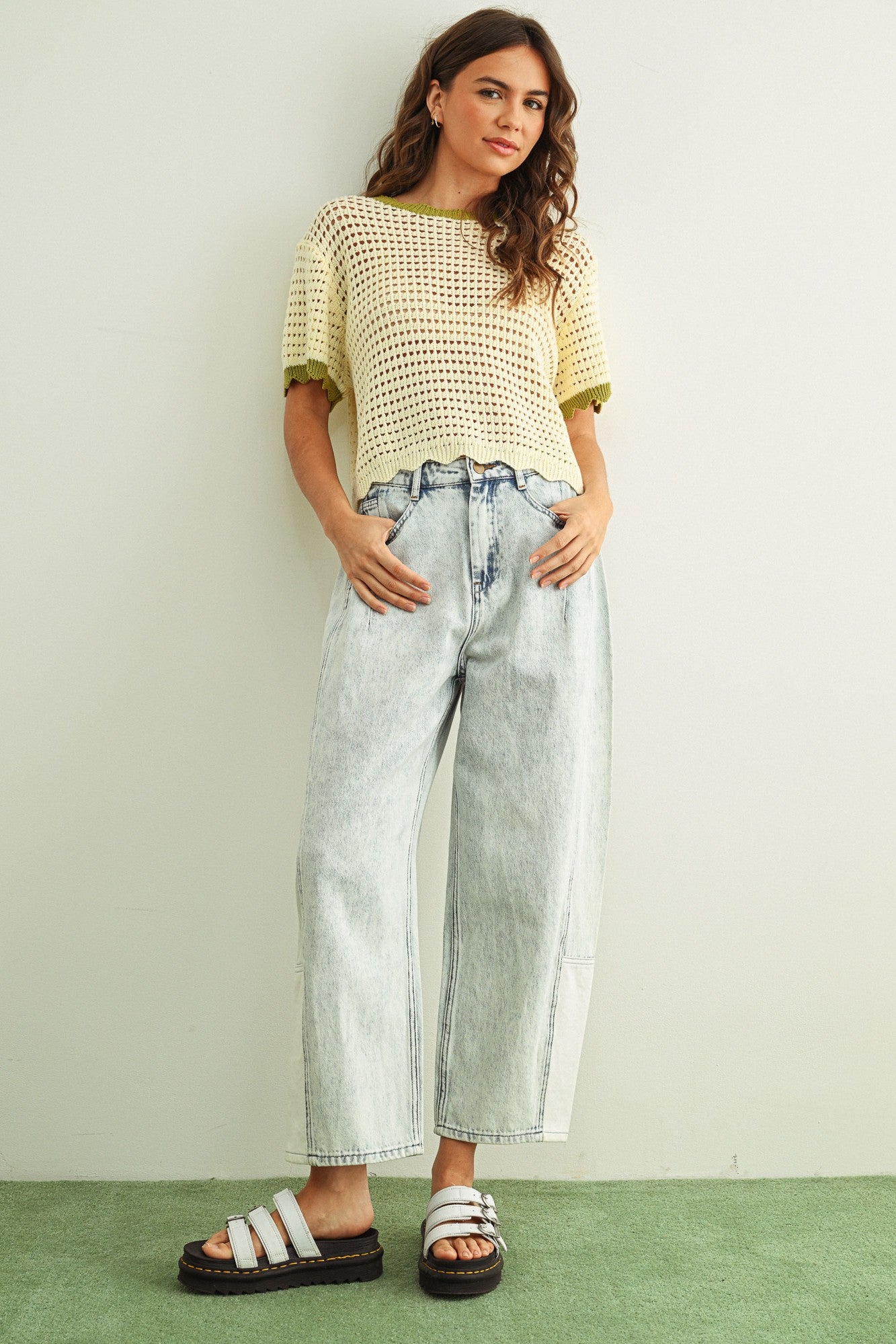 Woman wearing cream scalloped mesh knit short sleeve cotton top with sage trim