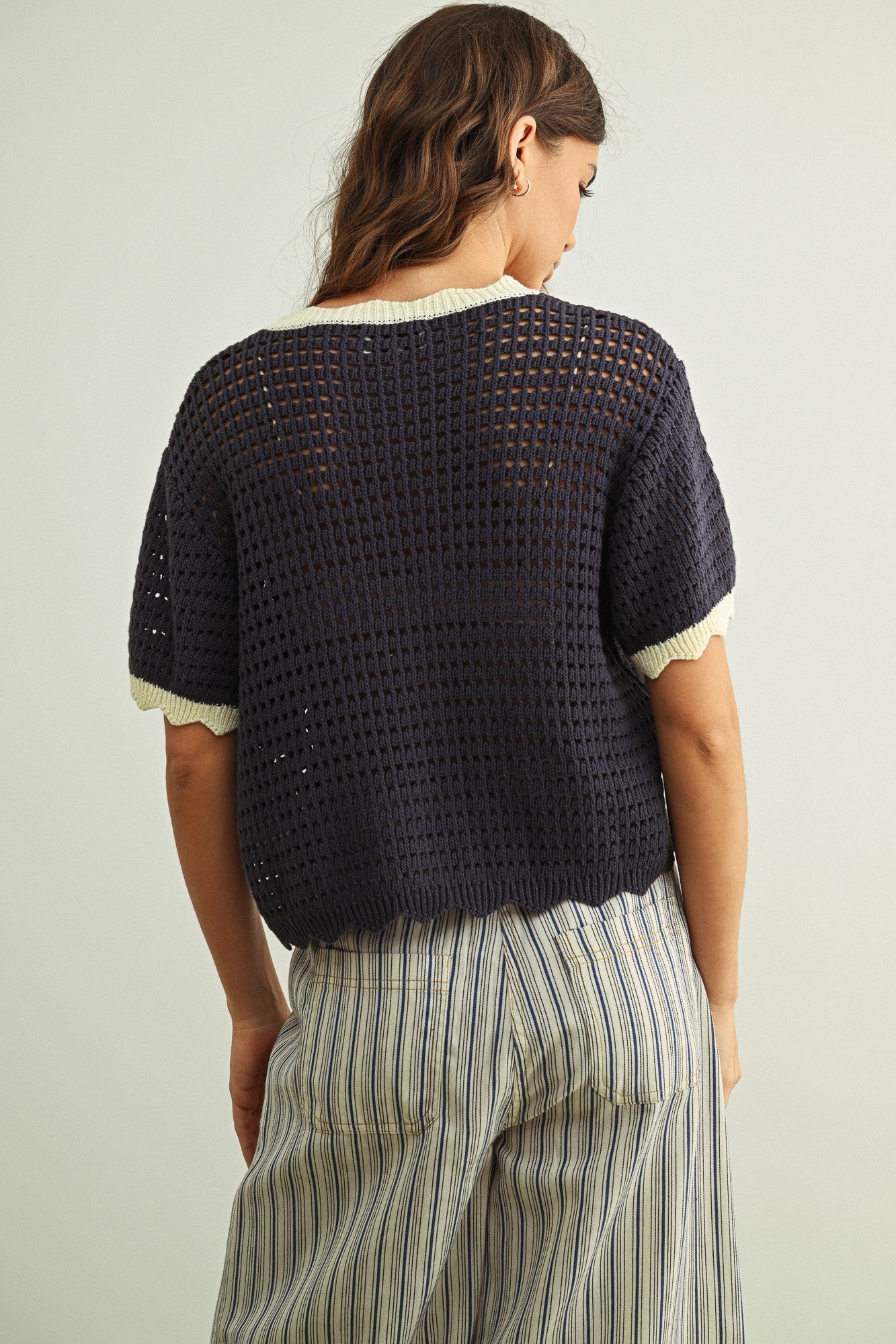 Back view of Scalloped Mesh Knit Short Sleeve Top in navy and cream, featuring an open knit texture and easy short sleeve silhouette.