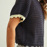 Close-up of navy and cream scalloped mesh knit top showing the open cotton knit texture and scalloped trim detail.