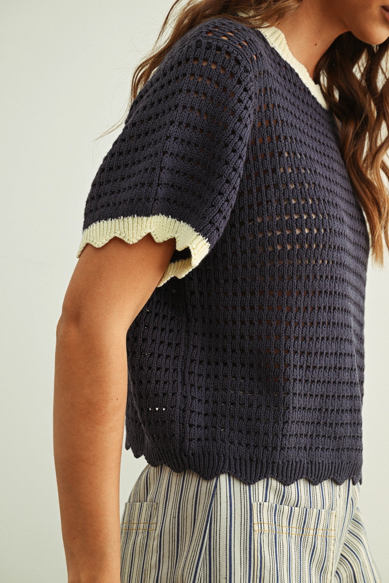 Close-up of navy and cream scalloped mesh knit top showing the open cotton knit texture and scalloped trim detail.