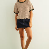 Woman wearing tan scalloped mesh knit short sleeve cotton top with olive trim