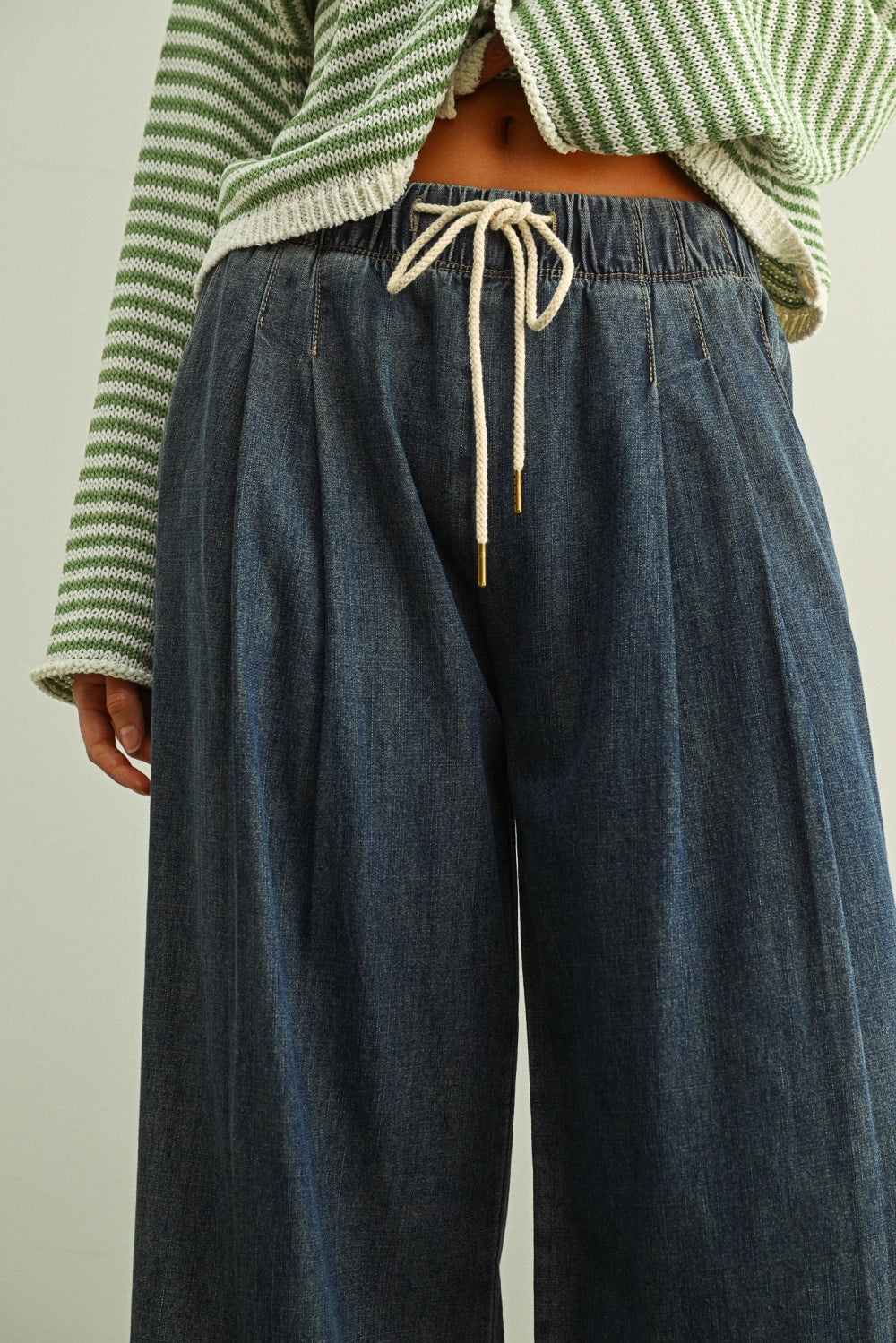 Close-up of Scout Lightweight Pull-On Wide Leg Jeans in denim with elastic waistband, drawstring waist, and front pleat detail