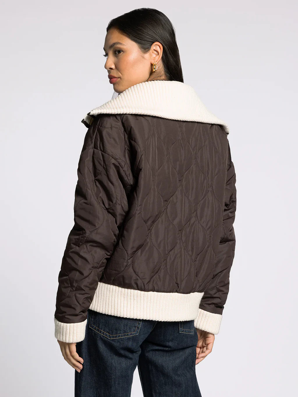 Back view of the brown quilted puffer jacket showing quilted pattern and knit trim at hem