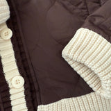 Close-up of the button detail and knit collar on the brown quilted puffer jacket
