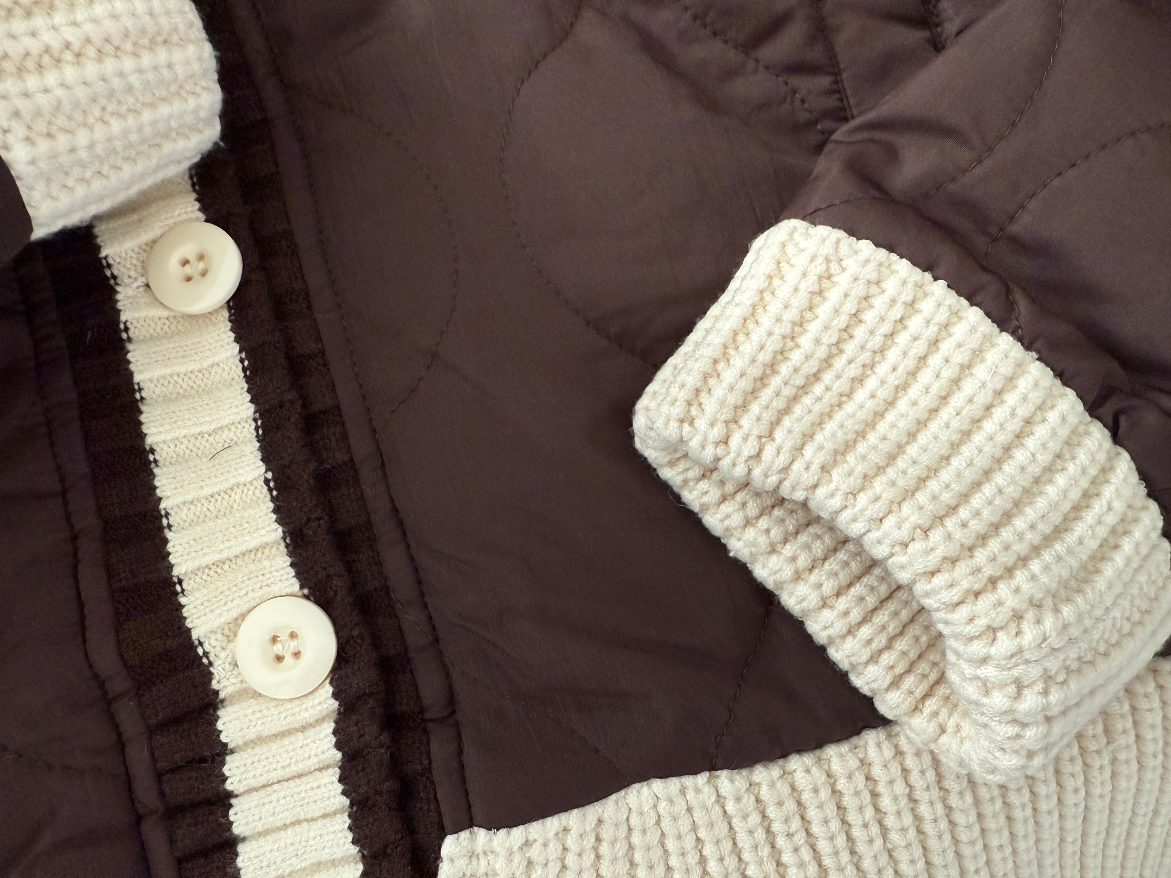 Close-up of the button detail and knit collar on the brown quilted puffer jacket