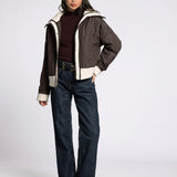 Full-body front view of model wearing the brown button-down quilted puffer jacket with jeans