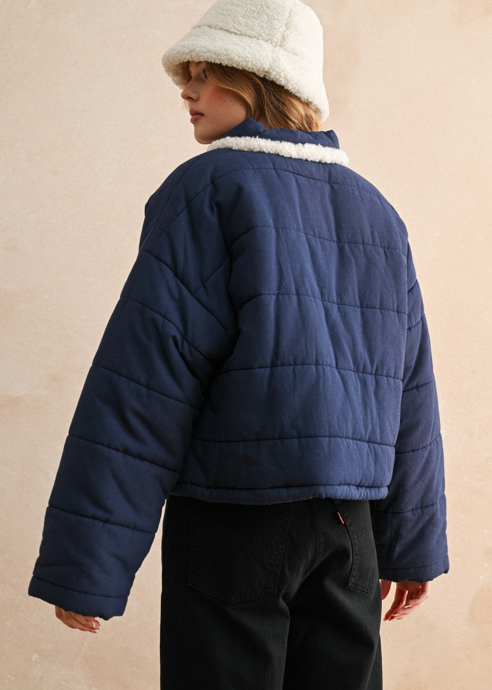 Back view of the blue quilted jacket showing the relaxed fit and puffer silhouette