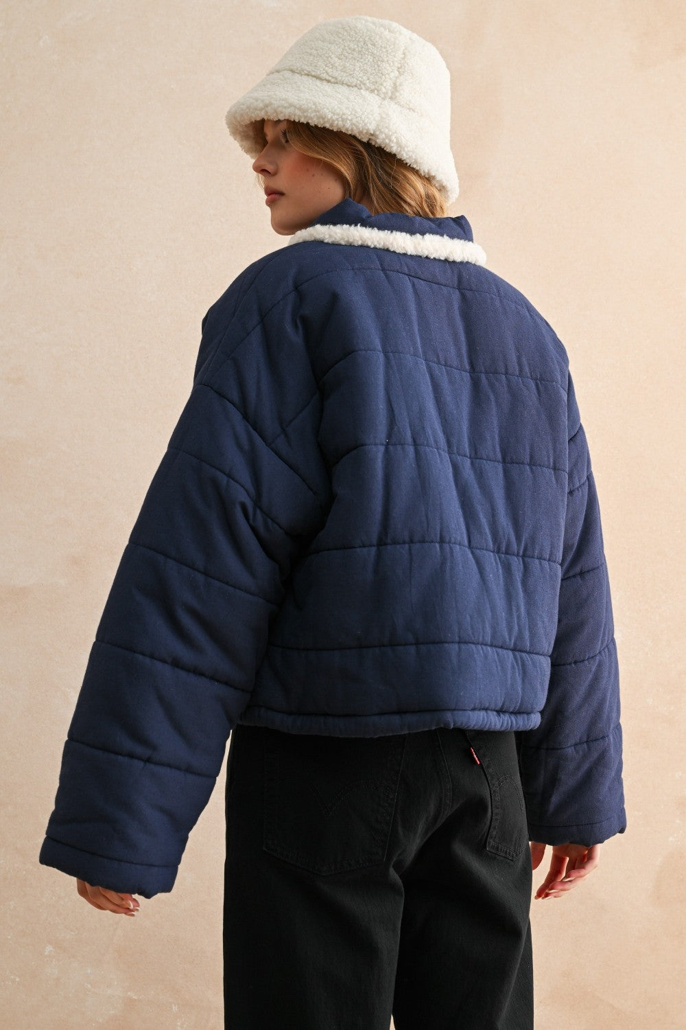 Back view of the blue quilted jacket showing the relaxed fit and puffer silhouette