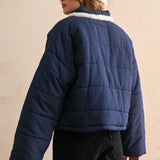 Back view of the blue quilted jacket showing the relaxed fit and puffer silhouette