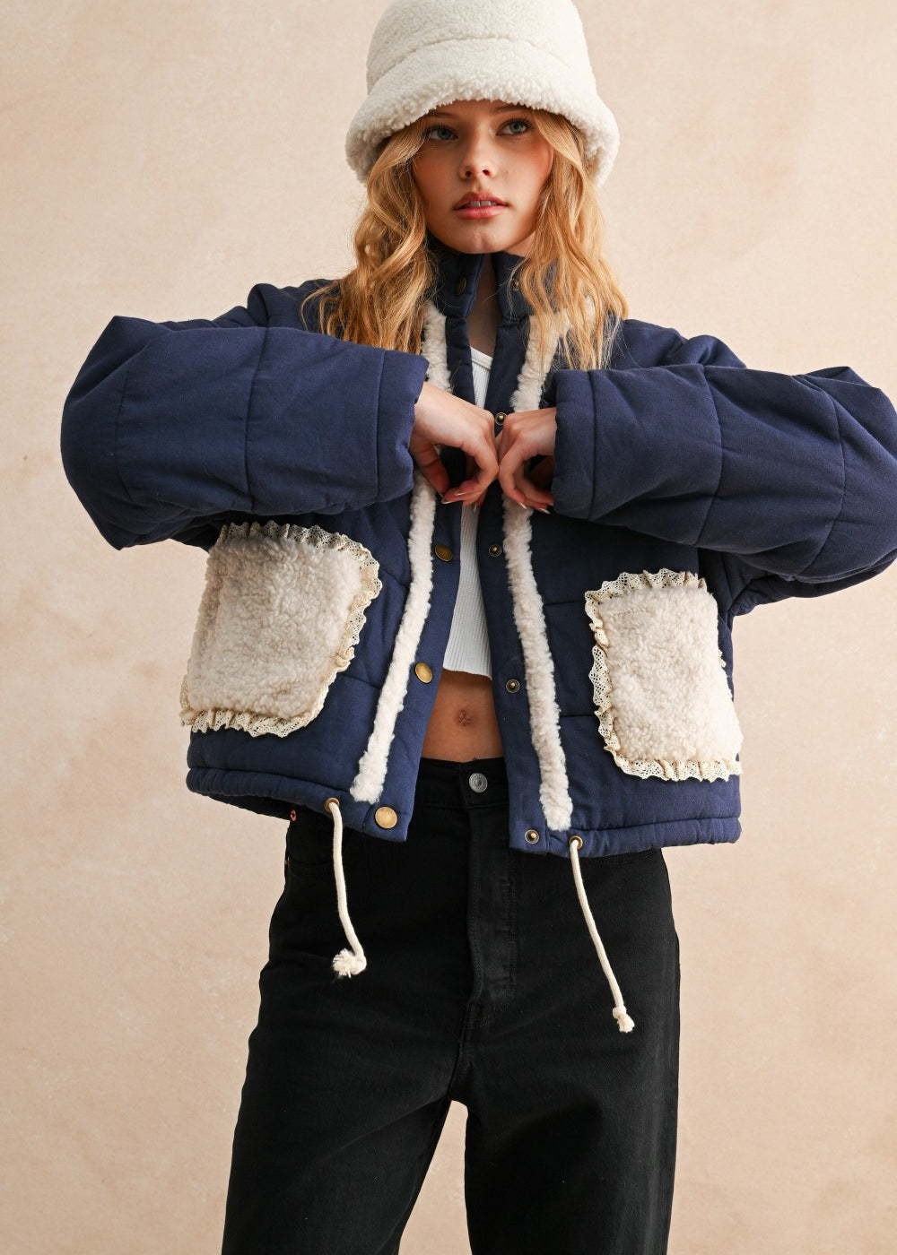 Model wearing the Sienna Sherpa Pocket Quilted Jacket in blue with sherpa-trim pockets, front portrait view