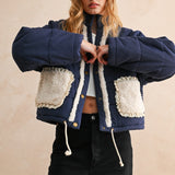 Model wearing the Sienna Sherpa Pocket Quilted Jacket in blue with sherpa-trim pockets, front portrait view
