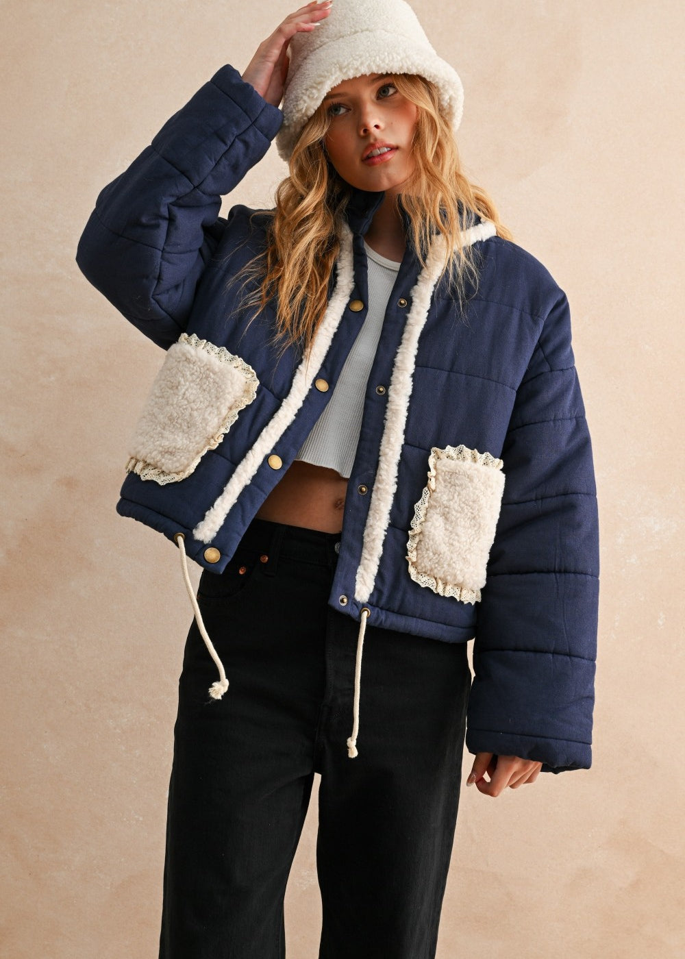 Front view of the Sienna Sherpa Pocket Quilted Jacket in blue with button-down front and drawstring hem