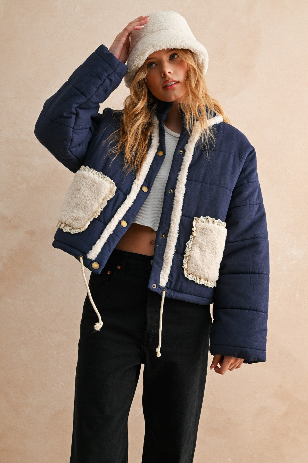 Front view of the Sienna Sherpa Pocket Quilted Jacket in blue with button-down front and drawstring hem