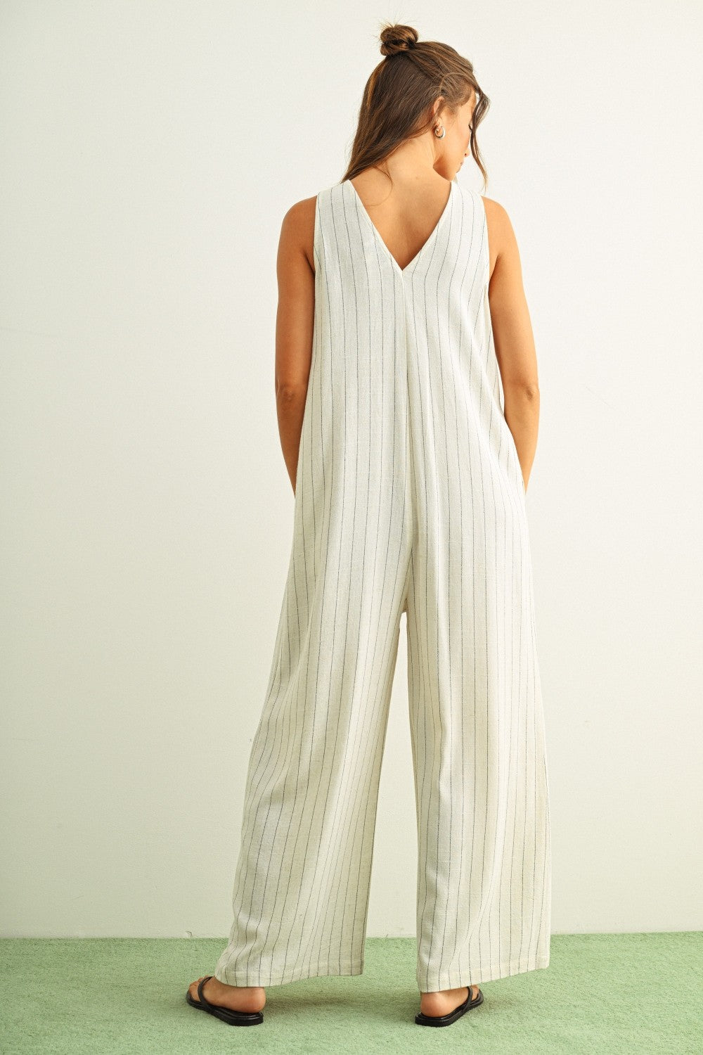 Back view of Sienna cream and black striped viscose linen jumpsuit with wide-leg silhouette