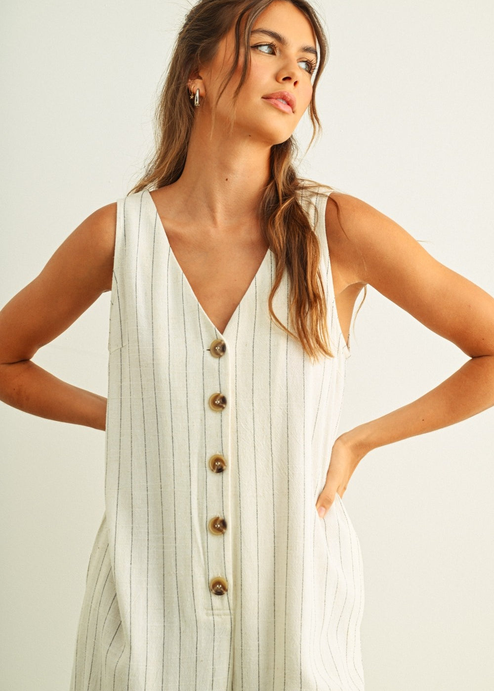 Close-up of button-front detail on Sienna cream and black striped jumpsuit