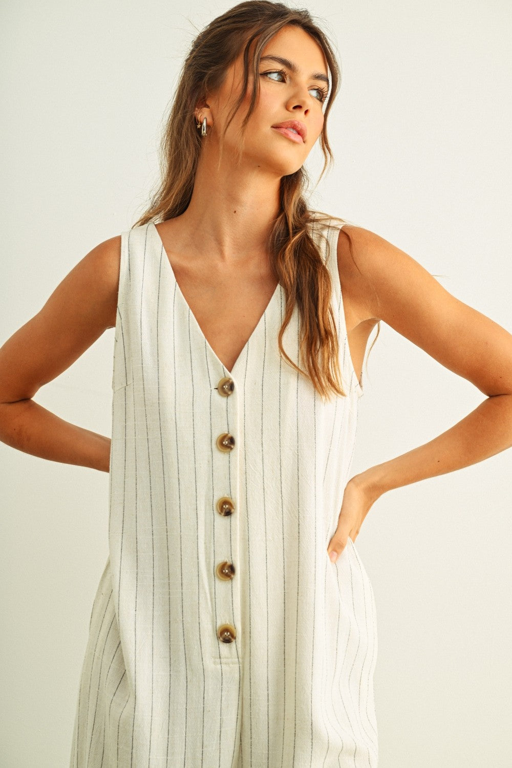 Close-up of button-front detail on Sienna cream and black striped jumpsuit