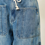 Close-up of Silverton medium wash barrel jeans featuring adjustable drawstring waist and patch pockets