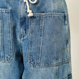 Close-up of Silverton medium wash barrel jeans featuring adjustable drawstring waist and patch pockets