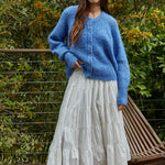 Full-body outfit: cobalt blue button cardigan styled with a white tiered midi skirt