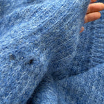 Close-up of sleeve detailing on the cobalt blue Skyline cardigan, subtle distressed finish